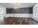 Elegant dining room showcases wainscoting, modern chandelier, and windows providing natural light at 4001 Belmont Forest Way, Raleigh, NC 27606