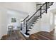 Bright foyer showcases a staircase with black railing and views to a living area at 4001 Belmont Forest Way, Raleigh, NC 27606