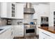 Bright kitchen featuring white cabinets, stainless steel appliances, marble countertops, and glass front cabinets at 4001 Belmont Forest Way, Raleigh, NC 27606