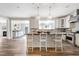 Open concept kitchen with white cabinets, stainless steel appliances, island with seating, and views to Gathering room at 4001 Belmont Forest Way, Raleigh, NC 27606