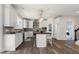 Bright kitchen with white cabinets, stainless steel appliances, island with seating, and modern lighting fixtures at 4001 Belmont Forest Way, Raleigh, NC 27606