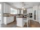 Well-lit kitchen featuring white cabinetry, stainless steel appliances, island with seating, and modern lighting at 4001 Belmont Forest Way, Raleigh, NC 27606