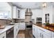 Bright kitchen with white cabinets, stainless steel appliances, marble countertops, and island with butcher block top at 4001 Belmont Forest Way, Raleigh, NC 27606