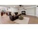 Cozy living room featuring a leather sofa, area rug, fireplace, and open access to the kitchen at 4001 Belmont Forest Way, Raleigh, NC 27606