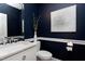 Stylish powder room with navy walls, white vanity, and modern accents at 4001 Belmont Forest Way, Raleigh, NC 27606