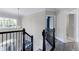 Elegant staircase with black iron railing and contemporary chandelier enhance the home's interior at 4001 Belmont Forest Way, Raleigh, NC 27606