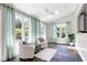 Bright sunroom with white chairs, patterned rug, tile floors, large windows with sheer curtains, and natural light at 4001 Belmont Forest Way, Raleigh, NC 27606