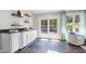 Bright sunroom with white cabinets, wet bar, tile floors, chair, and natural light at 4001 Belmont Forest Way, Raleigh, NC 27606