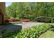 Expansive backyard with flowering shrubs, mature trees, covered parking, and a driveway leading to the home at 4298 Old Stage S Rd, Erwin, NC 28339
