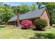 Exterior of brick home featuring yard with trees and flowers at 4298 Old Stage S Rd, Erwin, NC 28339
