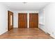 Bedroom featuring hardwood floors, a door, a window, and closet doors at 4298 Old Stage S Rd, Erwin, NC 28339