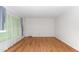 Bright bedroom with hardwood floors, white walls, and natural light from a large window at 4298 Old Stage S Rd, Erwin, NC 28339