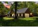Charming brick home with a well-maintained lawn, mature trees, and warm lighting at dusk at 4298 Old Stage S Rd, Erwin, NC 28339