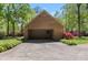 Brick garage with open doors, surrounded by flowering shrubs and mature trees, offering ample storage space at 4298 Old Stage S Rd, Erwin, NC 28339