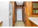 Galley kitchen featuring wood paneling, white appliances and easy access to the backyard at 4298 Old Stage S Rd, Erwin, NC 28339