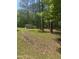View of an outbuilding on a large lot shaded by large trees at 4501 Duraleigh Rd, Raleigh, NC 27612