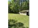 View of an outbuilding on a large lot shaded by large trees at 4501 Duraleigh Rd, Raleigh, NC 27612