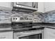 Stainless steel oven and microwave over granite countertops and stylish backsplash at 500 W Woodcroft Pkwy # 13D, Durham, NC 27713
