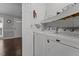 Convenient laundry room featuring modern washer and dryer units with overhead shelving at 500 W Woodcroft Pkwy # 13D, Durham, NC 27713