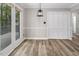 Dining area featuring wood-look floors, a modern light fixture, and access to outdoor deck at 500 W Woodcroft Pkwy # 17C, Durham, NC 27713