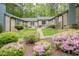Inviting townhome featuring fresh landscaping, colorful flowers, and a charming brick exterior at 500 W Woodcroft Pkwy # 17C, Durham, NC 27713