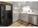 Well-lit kitchen featuring updated cabinets, granite countertops, and stainless steel appliances at 500 W Woodcroft Pkwy # 17C, Durham, NC 27713