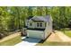New two-story home featuring a two-car garage and modern gray-green and white color scheme, surrounded by lush trees at 5022 Mockingbird Ln, Sanford, NC 27332