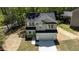 Newly built two-story home showcasing a two-car garage and modern gray and white exterior amidst a serene wooded area at 5022 Mockingbird Ln, Sanford, NC 27332