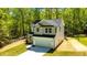 View of a newly constructed home with gray siding and a two car garage surrounded by mature trees at 5022 Mockingbird Ln, Sanford, NC 27332