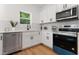 Bright kitchen features stainless steel appliances, white cabinets and modern tile backsplash at 5022 Mockingbird Ln, Sanford, NC 27332