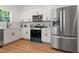 This modern kitchen is fitted with stainless steel appliances and sleek white cabinetry at 5022 Mockingbird Ln, Sanford, NC 27332