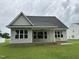 Exterior rear view features a covered porch, expansive lawn, and classic home design at 520 S Lincoln St, Benson, NC 27504