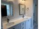 Elegant bathroom featuring double sinks, quartz countertops, decorative mirrors, and modern fixtures at 520 S Lincoln St, Benson, NC 27504