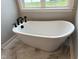 Inviting bathroom featuring a stand-alone soaking tub with modern matte black fixtures and marble tile flooring at 520 S Lincoln St, Benson, NC 27504