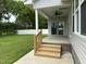 Inviting covered patio with wooden steps leading to a well-manicured lawn and fenced backyard at 520 S Lincoln St, Benson, NC 27504