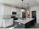 Bright kitchen featuring a large island, granite countertops, stainless appliances, and white cabinets at 520 S Lincoln St, Benson, NC 27504