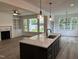 Spacious kitchen with granite countertops, an island with seating, and an open view to the living area at 520 S Lincoln St, Benson, NC 27504