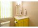 Charming powder room featuring unique wallpaper, bright yellow cabinets, and stylish fixtures at 5265 Aleppo Ln, Raleigh, NC 27613