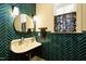 Stylish bathroom featuring a unique sink, elegant fixtures, and vibrant turquoise herringbone tile at 5265 Aleppo Ln, Raleigh, NC 27613