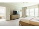 Bedroom featuring natural light, carpet, a flat-screen television, and a doorway to the ensuite bath at 5265 Aleppo Ln, Raleigh, NC 27613