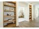 Hallway with hardwood floors, open built-in shelving, and doorway view into the beautifully designed bedroom at 5265 Aleppo Ln, Raleigh, NC 27613