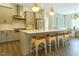 Spacious kitchen with stainless steel appliances, an island with seating, and modern pendant lighting at 5265 Aleppo Ln, Raleigh, NC 27613