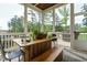 Screened-in porch with wood table, bench, chairs, and plant offering stunning views of the surrounding greenery at 5265 Aleppo Ln, Raleigh, NC 27613