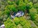 A scenic aerial view of a house surrounded by dense trees and flourishing foliage at 5504 Spring Bluffs Ln, Raleigh, NC 27606