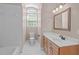 Bright bathroom featuring white tile, a modern vanity, a large mirror, and natural light at 5504 Spring Bluffs Ln, Raleigh, NC 27606
