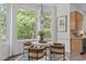 The breakfast nook features a modern chandelier, large windows, and overlooks the lush greenery at 5504 Spring Bluffs Ln, Raleigh, NC 27606