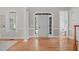 Bright foyer with hardwood floors, a white front door, and a view of the powder room at 5504 Spring Bluffs Ln, Raleigh, NC 27606