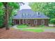 Charming brick home with a well-manicured lawn, mature trees, and inviting front entrance at 5504 Spring Bluffs Ln, Raleigh, NC 27606