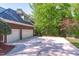 Spacious three car garage with a large driveway and a green lawn at 5504 Spring Bluffs Ln, Raleigh, NC 27606