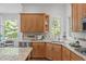 Kitchen featuring tile backsplash, granite countertops, stainless steel appliances, and a large window at 5504 Spring Bluffs Ln, Raleigh, NC 27606
